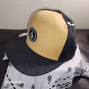Tan and black volcom snap back hat